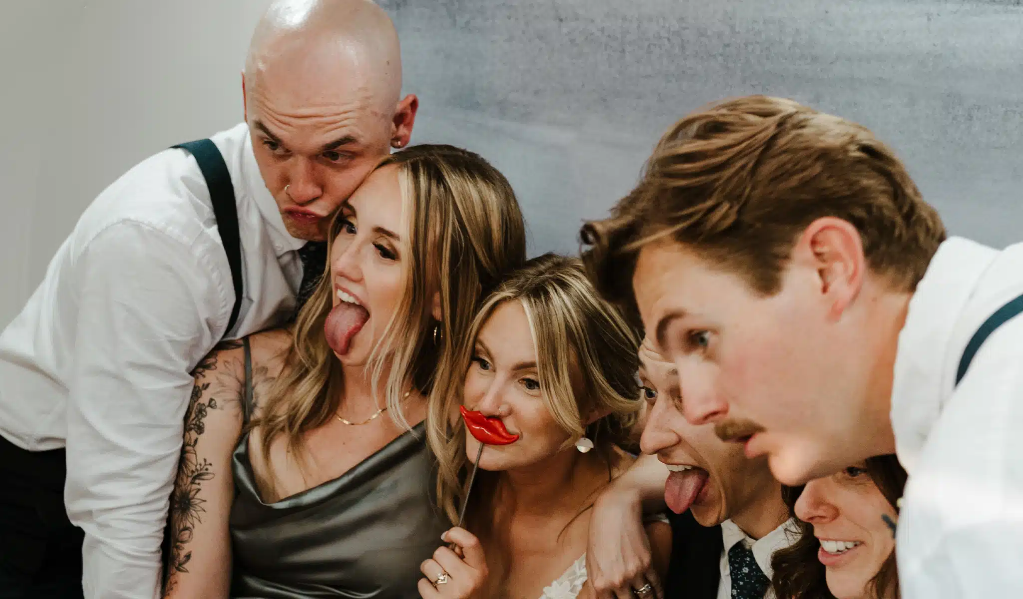 wedding party smiling for photo inside photo booth with lips